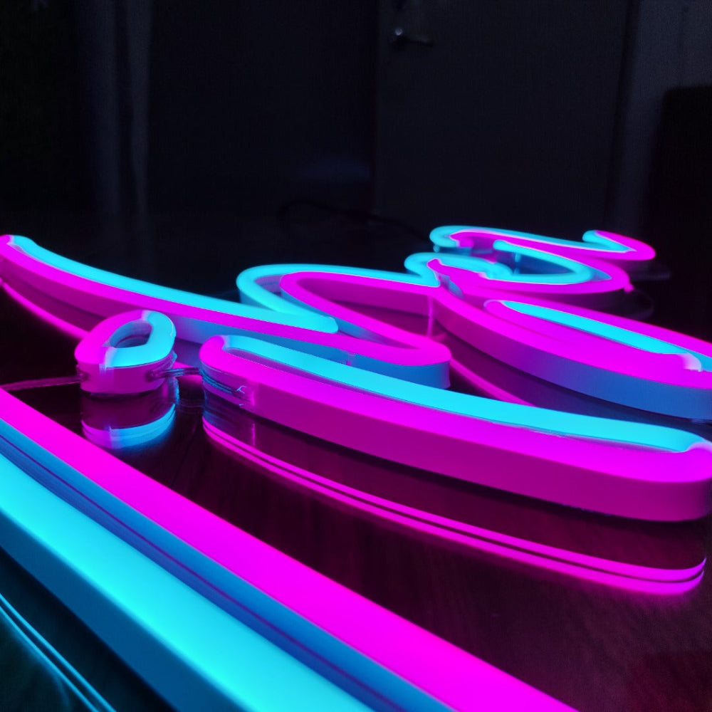 Neon sign with pink and blue lights on a dark background