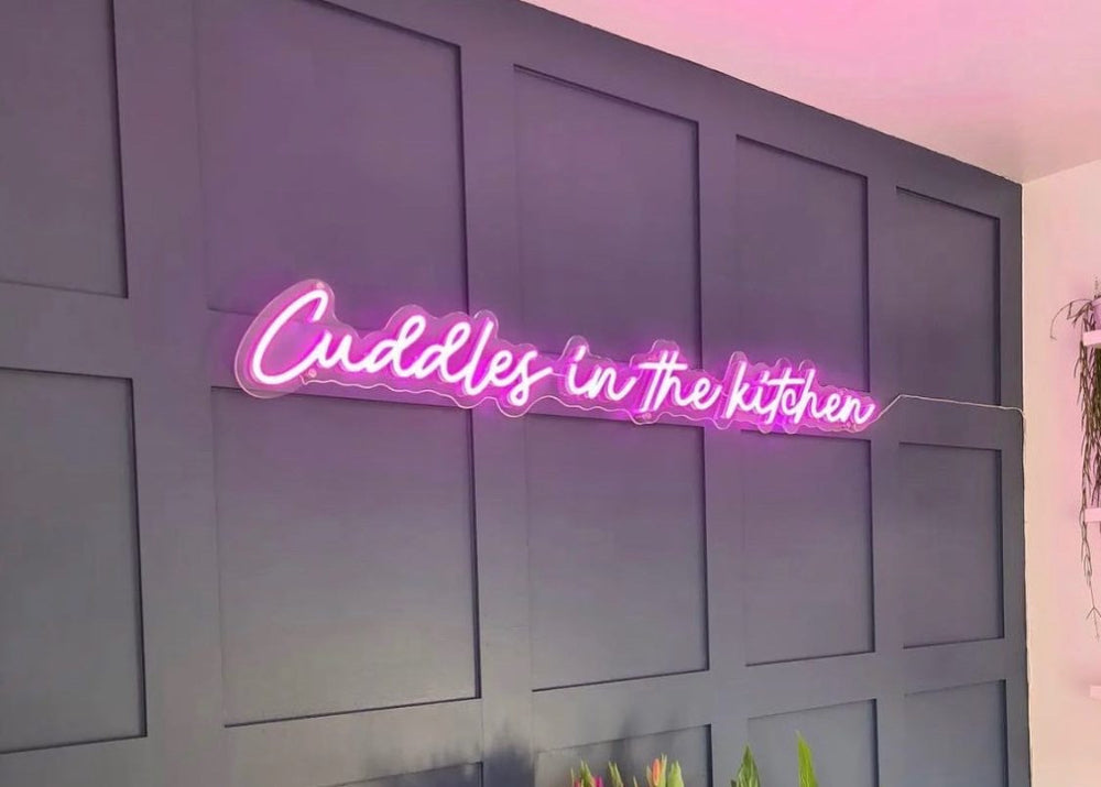 Pink Cuddles in the Kitchen LED neon sign glowing in a modern home kitchen